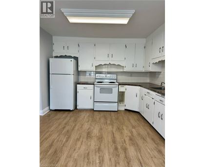 A kitchen with white appliances and cabinets.