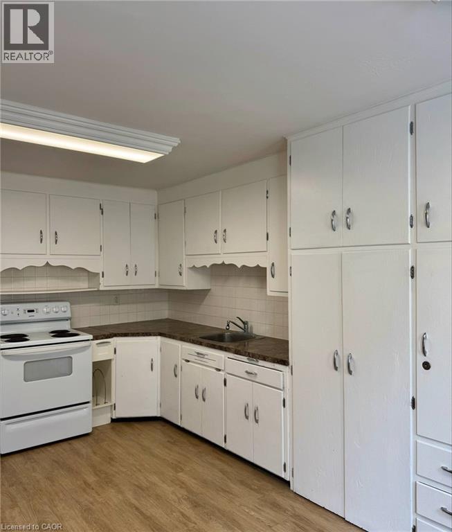 A kitchen with white cabinets and a stove top oven.