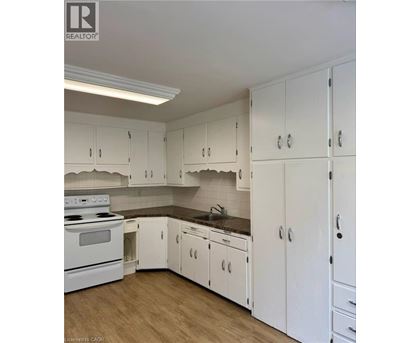 A kitchen with white cabinets and a stove top oven.
