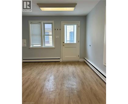 A room with a door, window, and wooden floor.