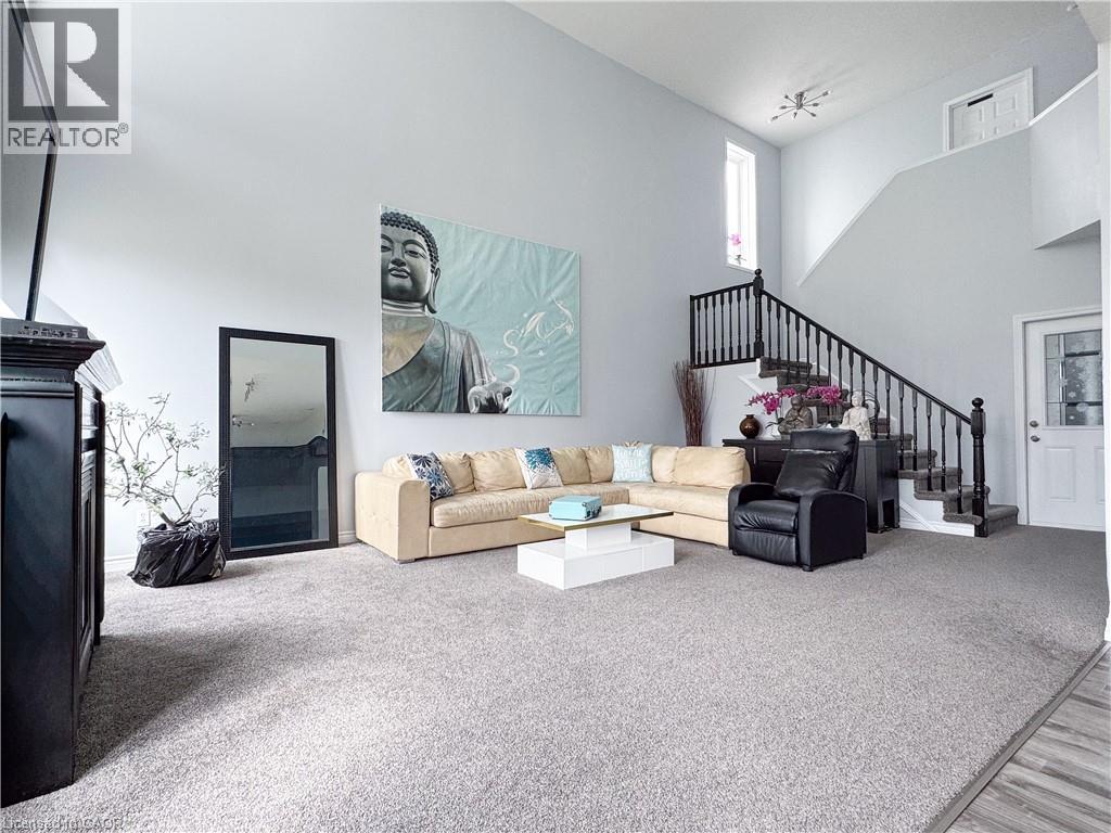 A living room with a white couch and a painting of Buddha on the wall.