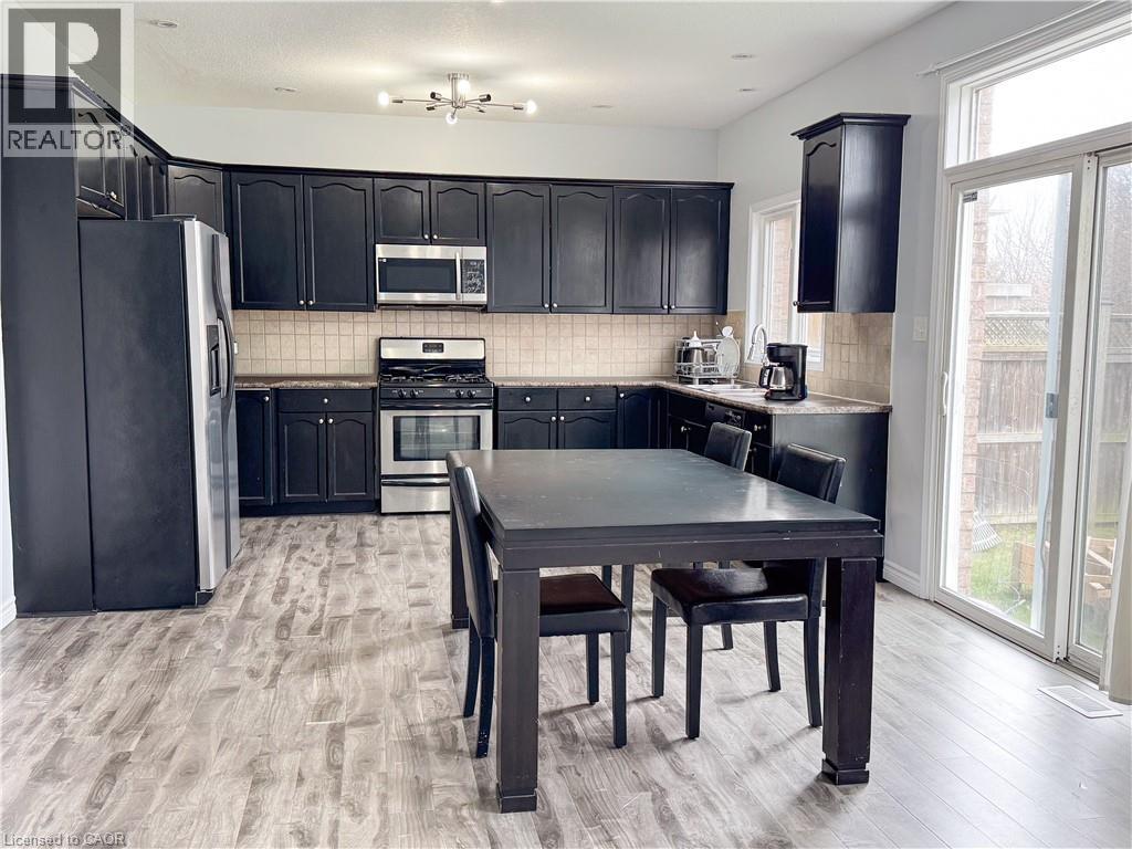 A kitchen with black cabinets and a table with chairs.