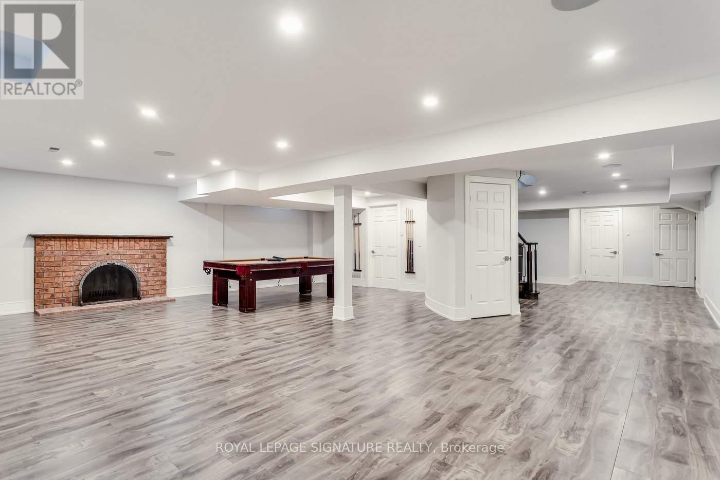 A spacious room with a fireplace and a pool table.