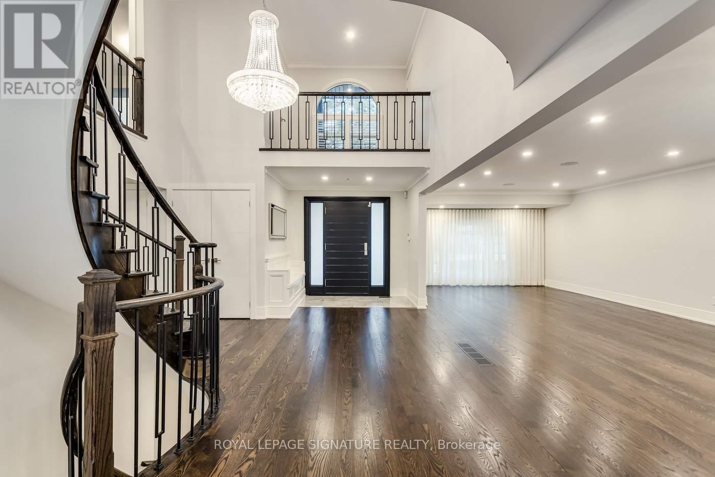 A spacious room with a wooden floor and a spiral staircase.