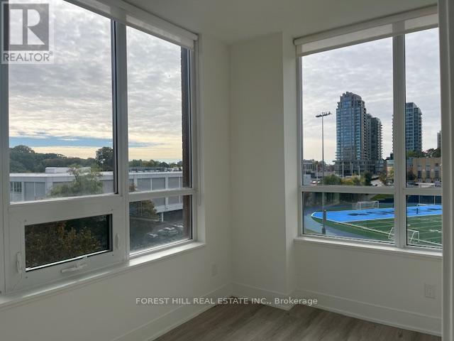 A room with two windows showing a view of a city skyline and a pool.