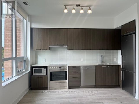 A modern kitchen with dark brown cabinets and stainless steel appliances.