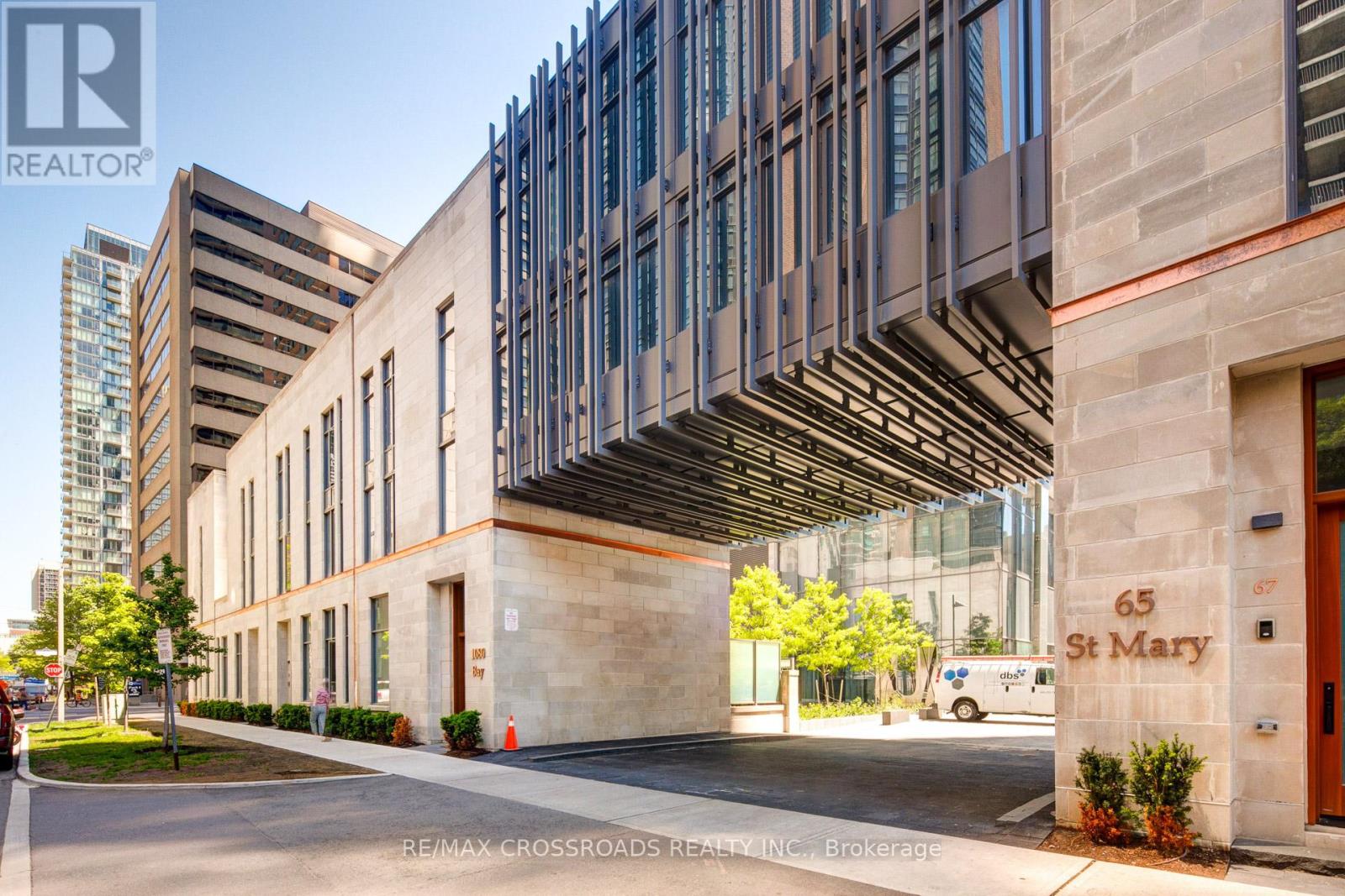 A modern building with a glass facade and a stone entrance.