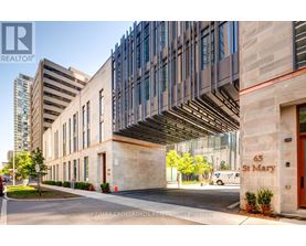 A modern building with a glass facade and a stone entrance.
