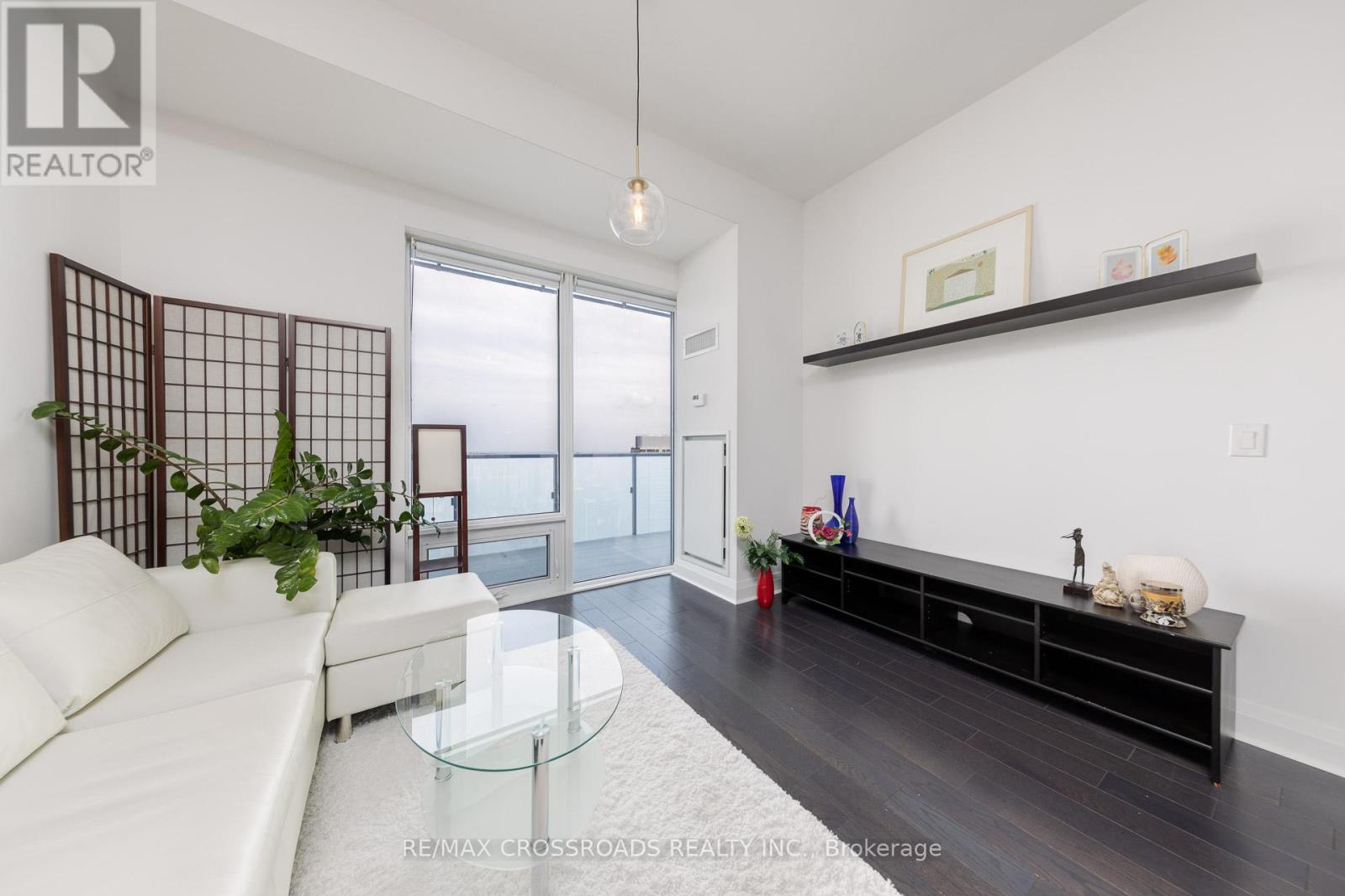 A living room with a white sofa and a glass coffee table.