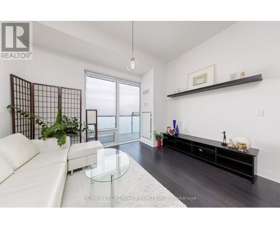 A living room with a white sofa and a glass coffee table.