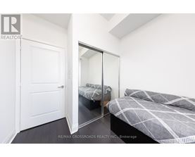 A bedroom with a bed and a mirrored closet door.