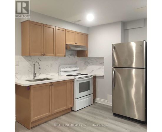 A kitchen with a stainless steel refrigerator, white oven, and wooden cabinets.