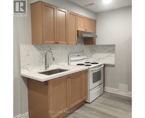 A kitchen with brown cabinets and a white stove top oven.