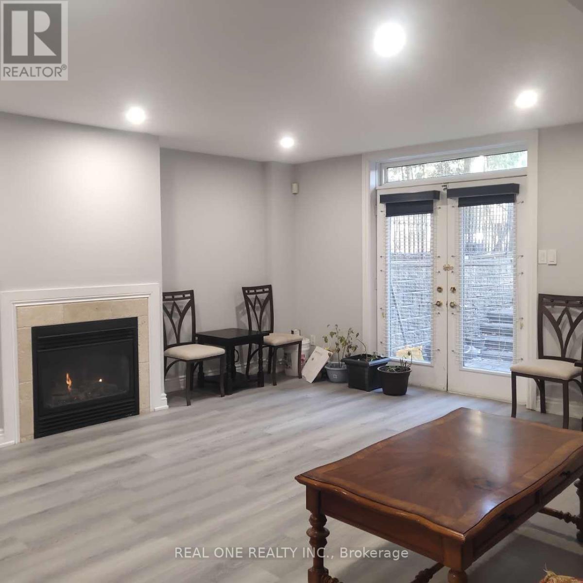 A living room with a fireplace and a dining table.