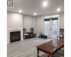 A living room with a fireplace and a dining table.