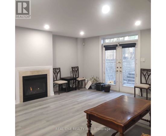 A living room with a fireplace and a dining table.