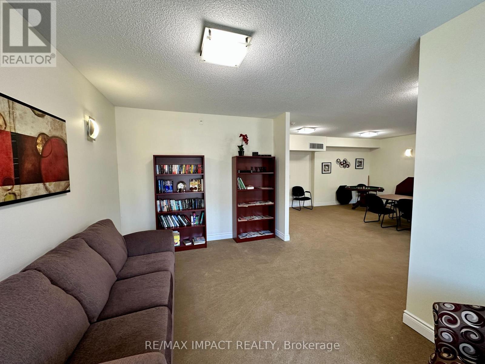 A living room with a brown sofa and a bookshelf.