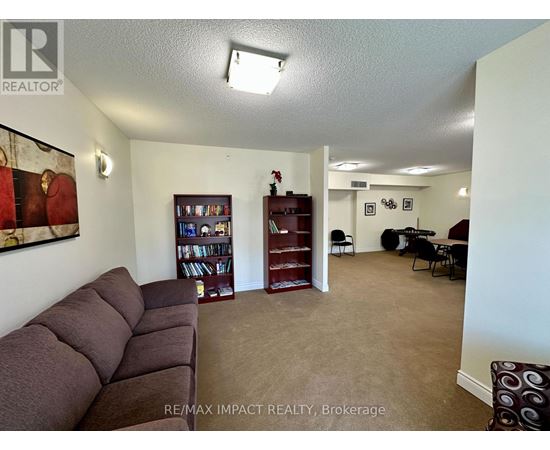 A living room with a brown sofa and a bookshelf.
