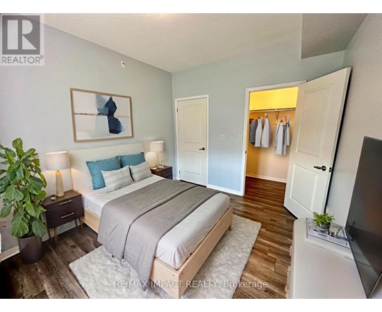 A bedroom with a bed, a plant, and a painting on the wall.