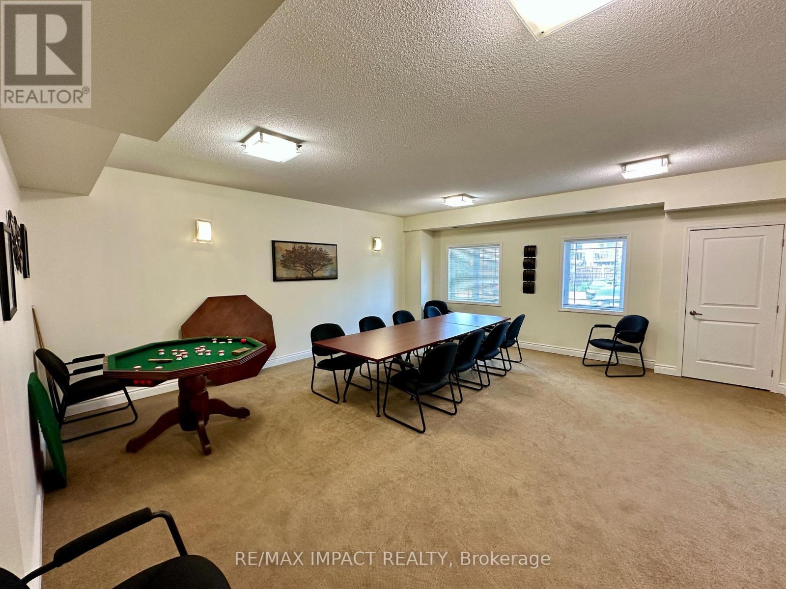 A room with a pool table and chairs.