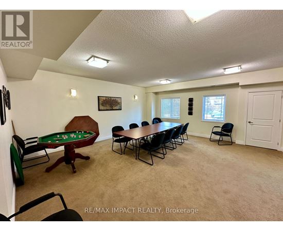 A room with a pool table and chairs.