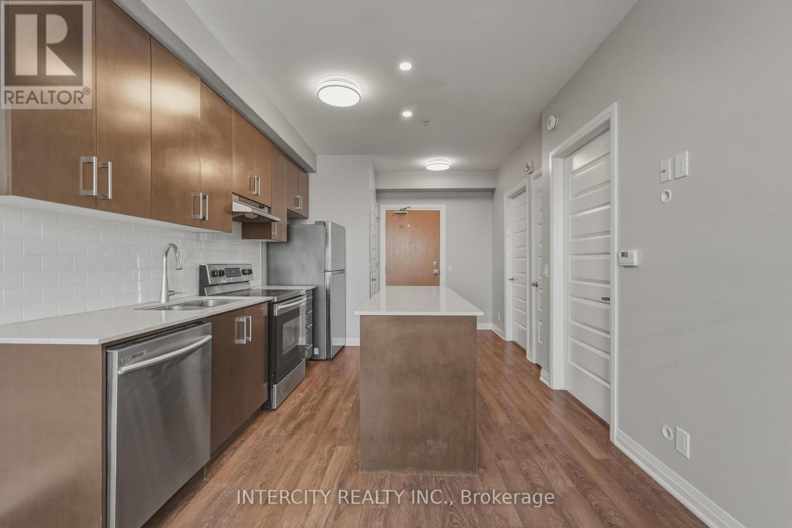 A kitchen with stainless steel appliances and wooden cabinets.