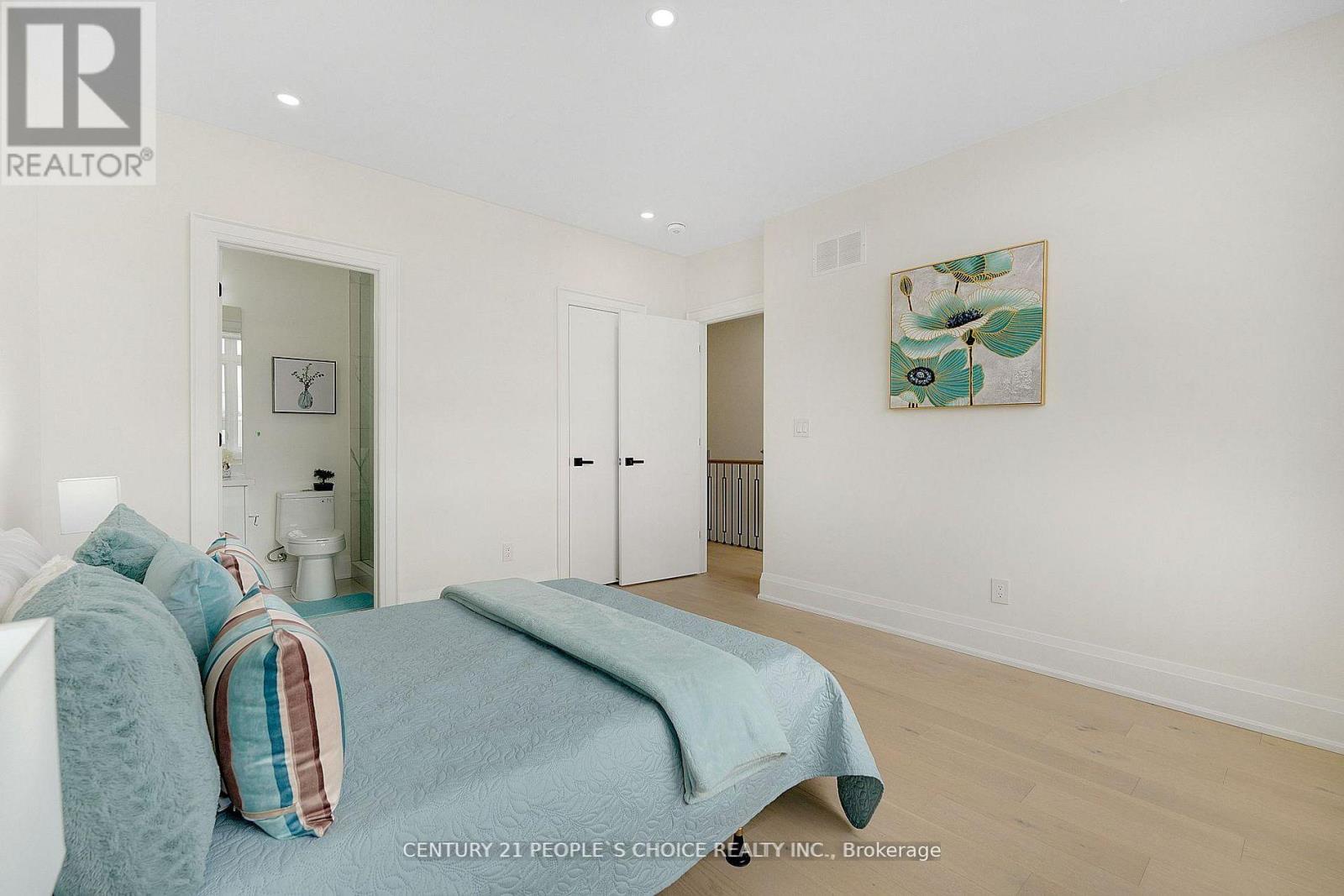 A bedroom with a bed and a painting on the wall.