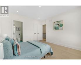 A bedroom with a bed and a painting on the wall.