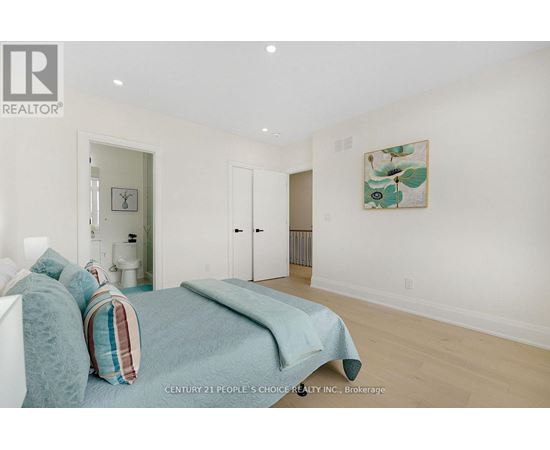 A bedroom with a bed and a painting on the wall.