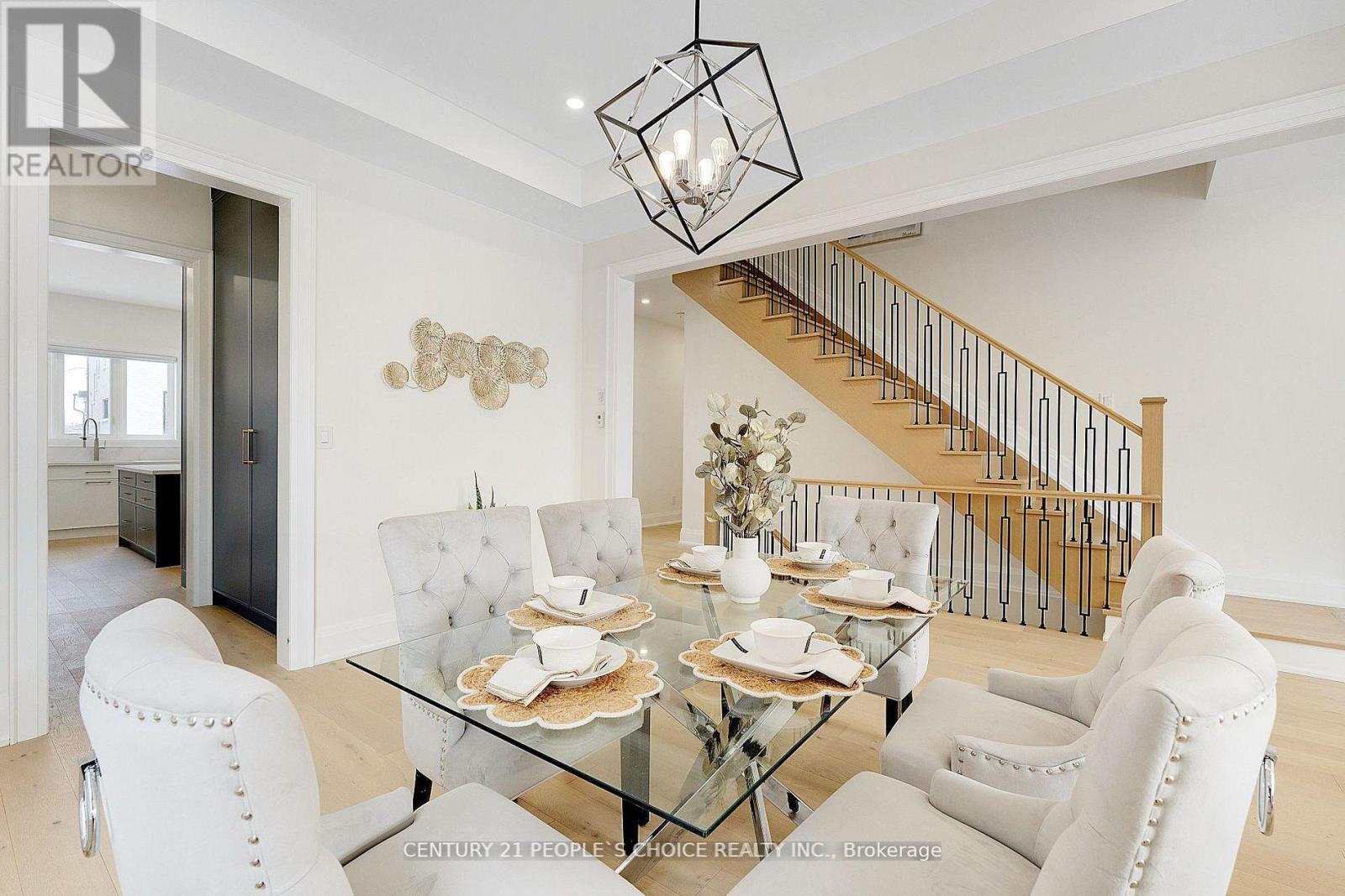 A dining room with a glass table and white chairs.