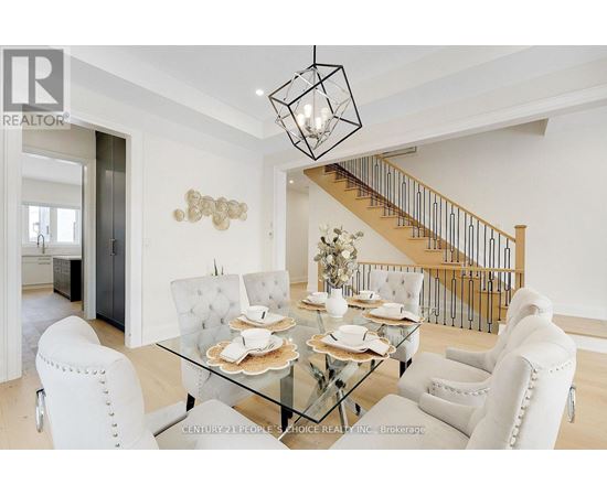A dining room with a glass table and white chairs.