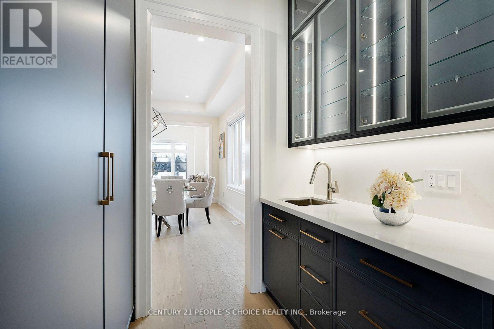 A modern kitchen with dark cabinets and a white countertop.