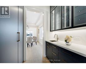 A modern kitchen with dark cabinets and a white countertop.