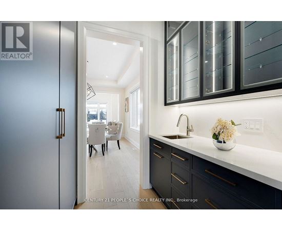 A modern kitchen with dark cabinets and a white countertop.