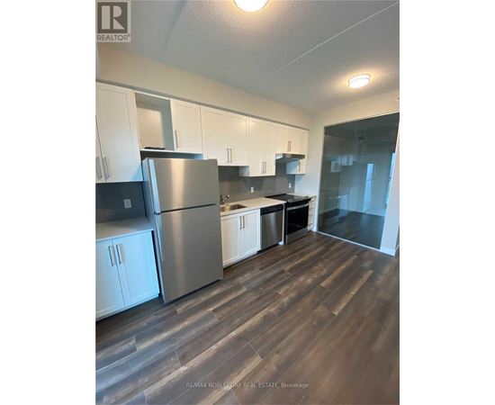 A kitchen with white cabinets and a stainless steel refrigerator.