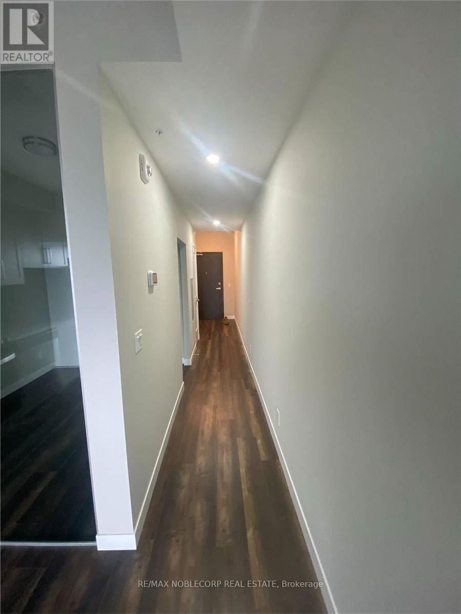 A hallway with wood floors and white walls.