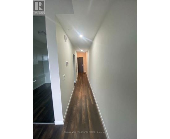 A hallway with wood floors and white walls.