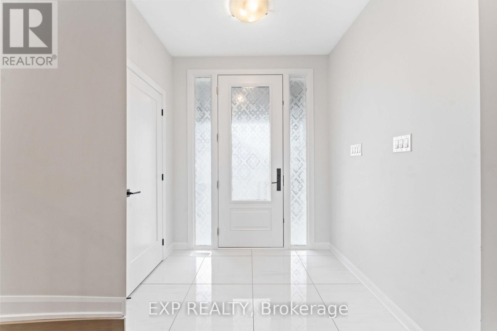 A hallway with a door and a light on the ceiling.