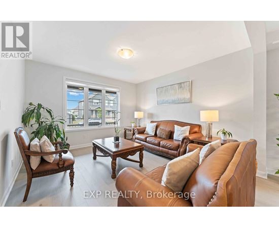 A living room with a brown leather couch and a wooden chair.