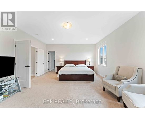 A bedroom with a bed, a chair, and a television.