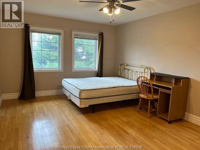 A bedroom with a bed, desk, and chair.