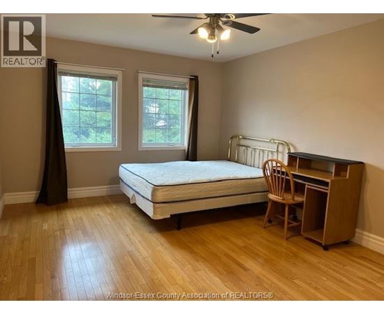 A bedroom with a bed, desk, and chair.