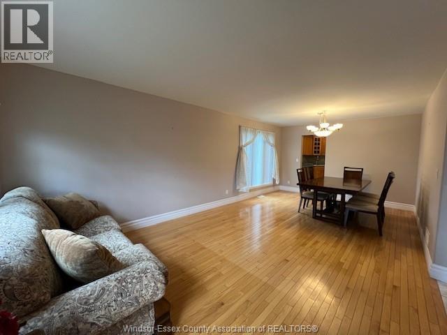 A living room with a couch, a chair, and a dining table.
