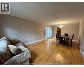 A living room with a couch, a chair, and a dining table.