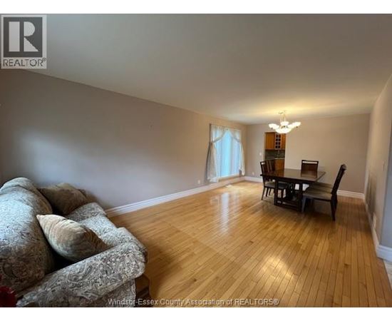A living room with a couch, a chair, and a dining table.