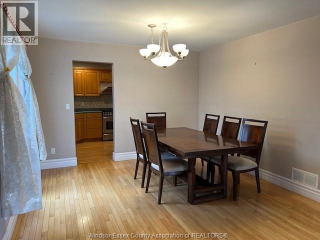 A dining room with a wooden table and chairs.