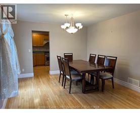 A dining room with a wooden table and chairs.