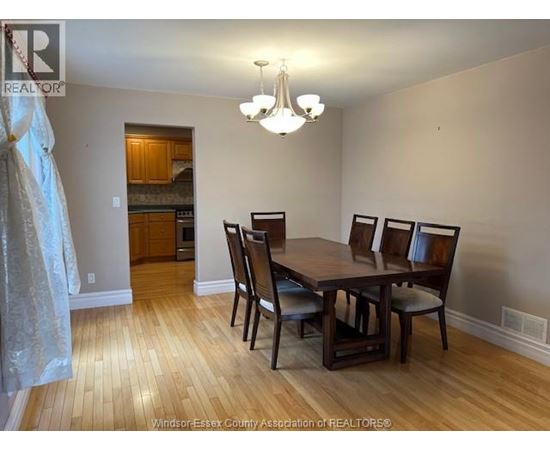 A dining room with a wooden table and chairs.