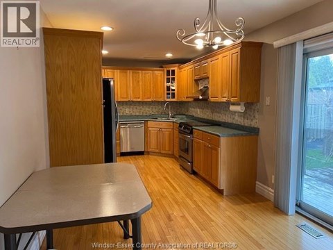 A kitchen with wooden cabinets and a table.