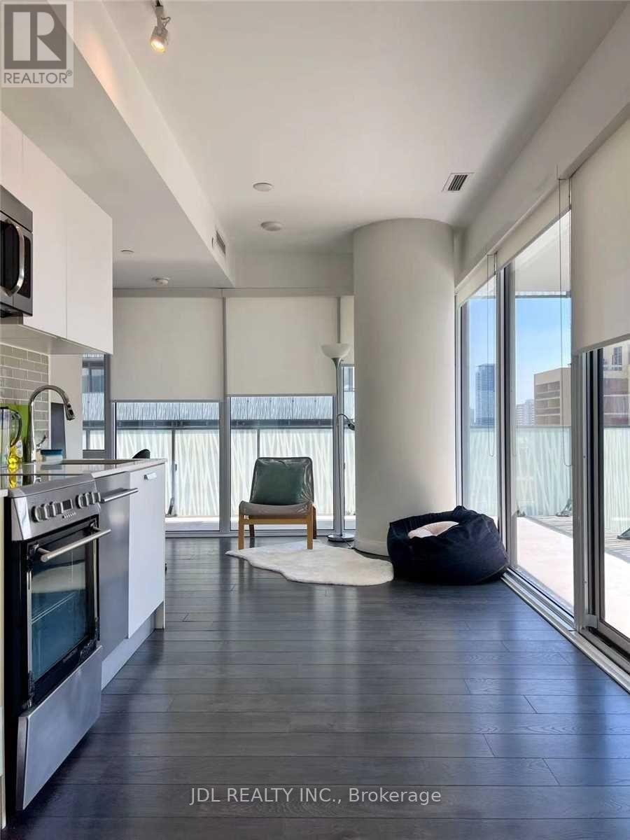 A modern kitchen with a stove top oven and a chair.